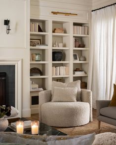 a living room filled with furniture and a fire place in front of a book shelf