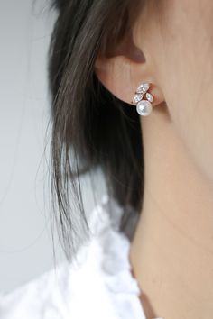 a close up of a person wearing some kind of earring with pearls on it