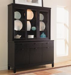 a black china cabinet with plates on it