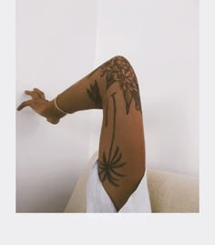 a woman's arm with flowers on it and her hand extended out to the side