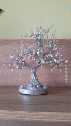 a small silver tree with pearls on it