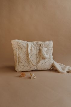 a white bag sitting on top of a table next to a pair of scissors and a towel