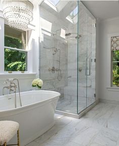 a bathroom with a tub, shower and window in it's center area is shown