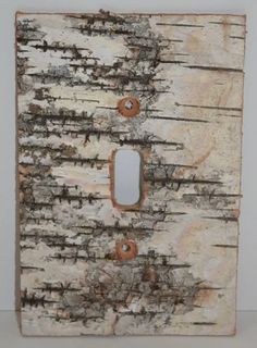 an old light switch cover with peeling paint on the outside and wood in the inside