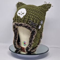 a knitted hat with a white skull on it's side and a fur lined brim