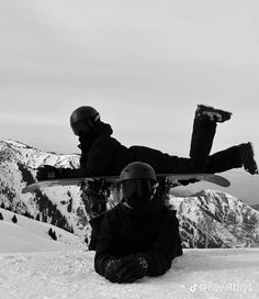 two snowboarders sitting in the snow with their boards on their heads and feet