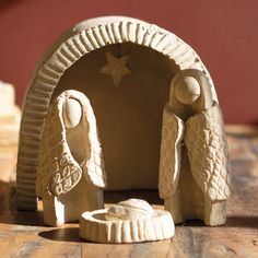 two ceramic figurines sitting on top of a wooden table