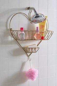 a heart shaped shower caddy with soap, shampoo and lotion on it