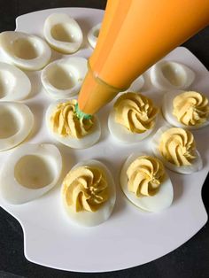 deviled eggs are arranged on a plate with an orange cone sticking out of them