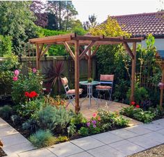 an outdoor garden with flowers and plants around the area, including a pergolated gazebo