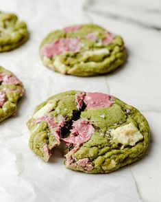 cookies with pink and green frosting are on the table