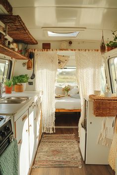 the inside of a camper with a bed, sink and stove top oven in it