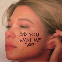 a woman with the words say you want me too painted on her face and behind her ear