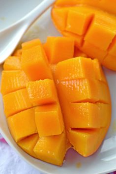 cut up pieces of mango on a white plate