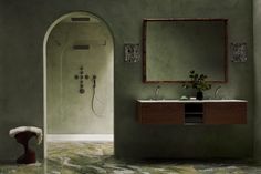 a bathroom with green walls and marble flooring