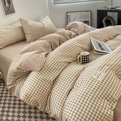 a bed with brown and white checkered comforter next to a black and white checkered floor