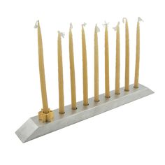 seven candles are lined up on a metal stand