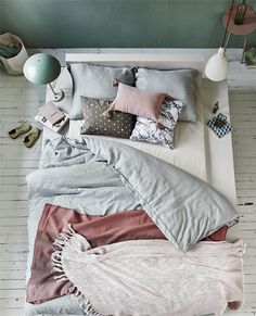 an image of a bed with pillows and blankets on it, in the japanese language