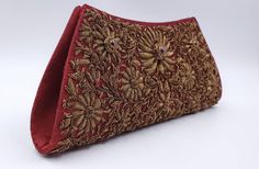 "Add instant glamour and elegance to any evening ensemble with this stunningly beautiful rich burgundy red silk evening bag clutch, intricately hand embroidered by zardozi artisans with copper metallic flowers and embellished with genuine star rubies to create an opulent, sophisticated 3D effect. Such rare artistry and craftsmanship! This is an exclusive piece, a wardrobe investment piece, a modern heirloom. More than fashion, it is an object d'art, inspired by the legacy of royalty. Zardozi mea Gold Clutch Bag With Intricate Embroidery, Gold Clutch With Intricate Embroidery, Traditional Red Embroidered Evening Bag, Red Luxury Bag For Festive Season, Luxury Red Bags For Festive Season, Traditional Embroidered Evening Bags, Traditional Formal Bags With Zari Work, Elegant Evening Bag For Wedding And Festivals, Elegant Evening Bag For Wedding