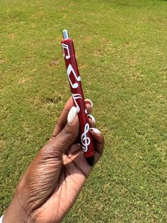 a hand holding a candy bar with musical notes on it in the middle of a grassy field