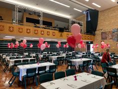 tables and chairs are set up for a party with balloons in the shape of hearts