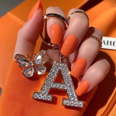 a woman's hand with an orange manicure and ring