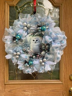 a wreath with an owl on the front door