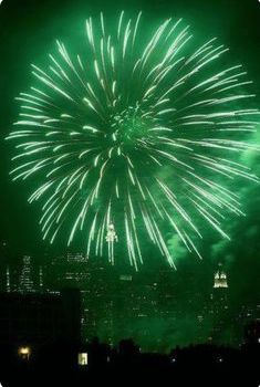 fireworks are lit up in the night sky above a cityscape and skyscrapers