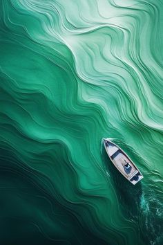 a small boat floating on top of a body of water next to a large wave