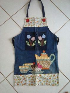 an apron made out of old jeans with patchwork and flowers on the front pocket