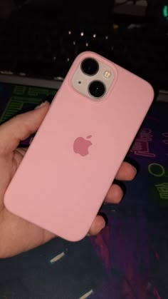 a person holding an apple phone in their hand with the back cover removed from it