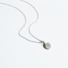 This simple, minimalistic sterling silver pebble gemstone necklace is perfect on its own, or layered with other necklaces. Each pebble has a 2mm Brilliant cut Charles And Colvard Moissanite flush set into the sterling silver pebble. - Chain length either 16", 18" or 20" - Chain style / Trace Each pendant is handmade so may vary slightly from the image, that's what makes it so special and unique! Handmade to order so please allow upto 7 days but do let me know if you need your order for a specifi Simple Design Sterling Silver Necklace, Silver Minimalist Charm Necklaces With Delicate Chain, Minimalist Silver Charm Necklaces With Delicate Chain, Delicate Sterling Silver Round Disc Jewelry, Delicate Sterling Silver Round Disc Necklace, Simple Sterling Silver Initial Pendant Necklace, Sterling Silver Delicate Round Disc Jewelry, Sterling Silver Round Disc Delicate Jewelry, Delicate Round Solitaire Necklace In Sterling Silver