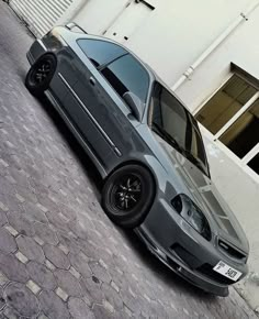 a grey car parked in front of a building