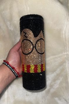 a hand holding a harry potter sequined tumbler cup with glasses on it