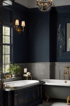 a bathroom with dark blue walls and gold trimming on the bathtub, chandelier