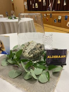 the table is set up with flowers, rocks and cards for guests to write their names