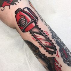 a man with a tattoo on his arm holding a red and black sawtoother