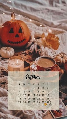 a desktop calendar with pumpkins, candles and other items on the bed in front of it