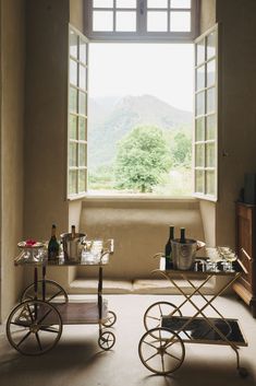 a living room filled with furniture and a large window overlooking the mountain range in the distance