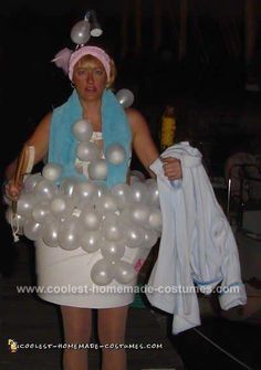 a woman is dressed up as a bucket full of silver balloons and holding a bottle