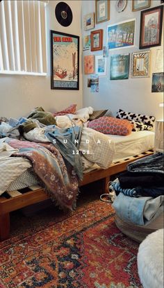 an unmade bed sitting on top of a rug in a bedroom