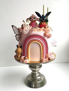 there is a cake decorated with animals and rainbows on the top of the cake