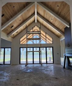 the inside of a building that is being built with wooden beams and glass doors on both sides