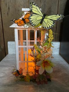 two butterflies on top of a lantern with flowers