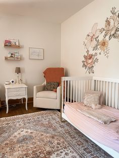 a baby's room with a crib, chair and rug