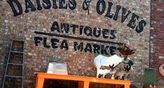 there is a statue of a cow on top of a table in front of a building