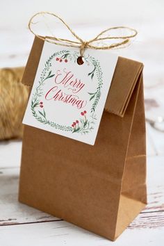 a brown paper bag with a merry christmas tag on it and twine spool