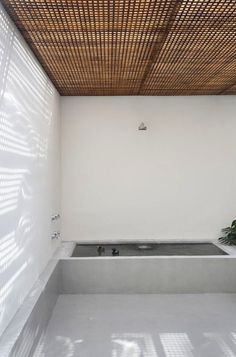 a white bathroom with a bamboo ceiling and bathtub