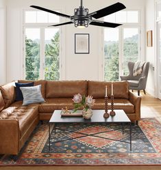 a living room with a couch, coffee table and ceiling fan in the middle of it