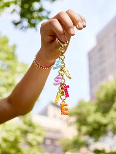 a person is holding up some charms in the air with one hand and two fingers